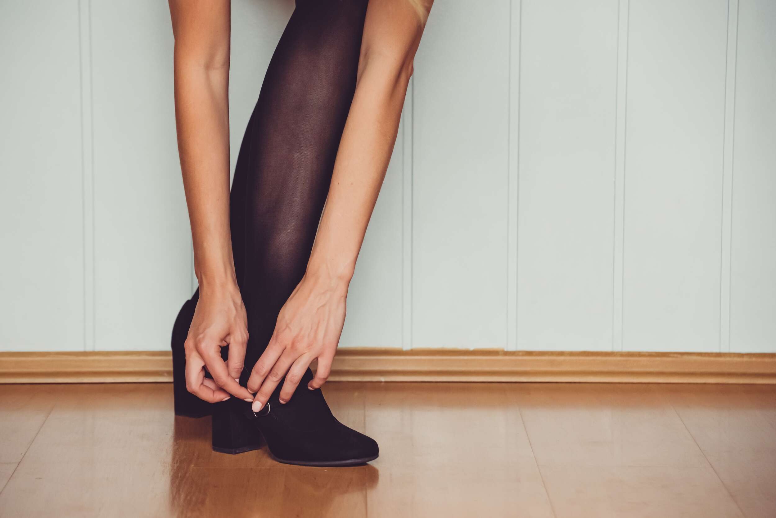 A,Woman,In,Black,Stockings,Or,Tights,Leans,Over,And